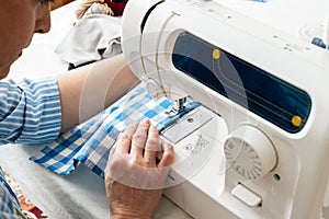 Woman using a sewing machine in tailor workshop