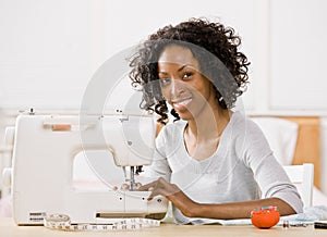 Woman using sewing machine to sew clothing