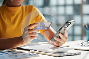 Woman using shopping application by smartphone and payment by credit card.