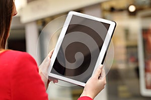 Woman using and showing a blank tablet screen