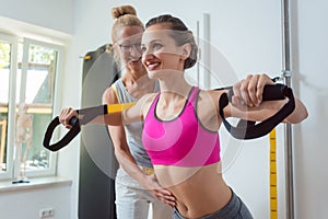 Woman using sling trainer during physical therapy to recover from an injury