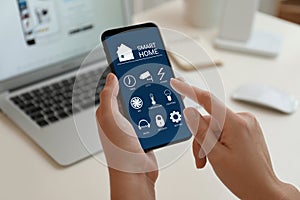 Woman using Smart Home app on phone indoors, closeup