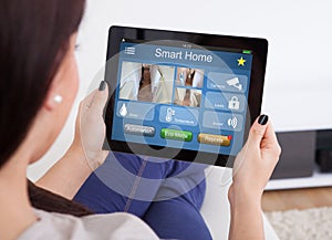 Woman Using Smart Home System On Digital Tablet photo