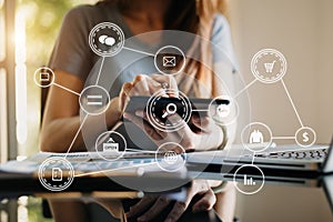 Woman using smart phone for mobile payments online shopping,omni channel,sitting on table,virtual icons graphics interface screen