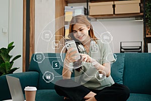 Woman using smart phone for mobile payments online shopping,omni channel,sitting on table,virtual icons graphics interface screen