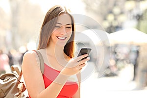 Woman using a smart phone in the street in summer