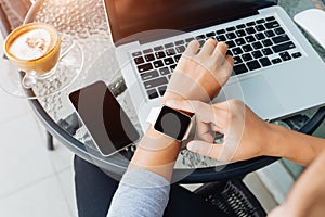 Woman using smart watch in coffee shop