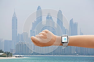 Woman using smart watch music application on beach