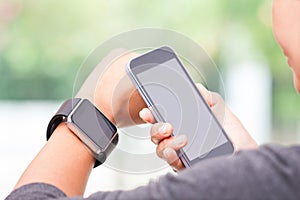 Woman using smart watch and smart phone.