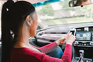 Woman using smartphone app on modern car. Mobile phone application, map navigation device technology, transportation concept