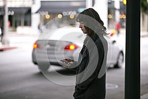 Woman Using a Smartphone App Waiting for a Rideshare photo