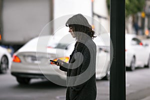 Woman Using a Smartphone App Waiting for a Rideshare photo