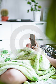 woman using a smartphone in bed