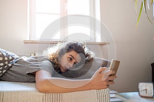 Woman using smartphone in bed