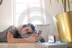 Woman using smartphone in bed