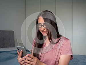 woman using smartphone on the bed