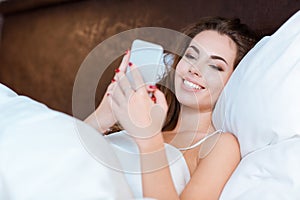 Woman using smartphone on the bed