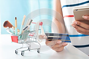 Woman using smartphone and credit card shopping beauty items. Online shopping, e-payment
