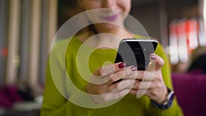 Woman using smartphone and drinking coffee in cafe close up