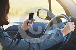 Woman using smartphone while driving a car