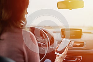 Woman using a smartphone while driving. Unsafe driving concept