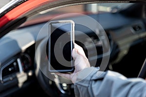 Woman using smartphone in front of the car. Communication or connect to an app. Car sharing