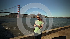 Woman using smartphone by the Golden Gate Bridge