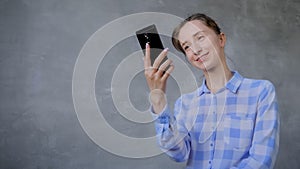 Woman using smartphone, having video chat or taking selfie