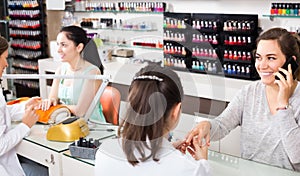 woman using smartphone during manicure at nail salon