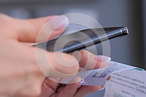 Woman using smartphone and scanning qr code on cash shop receipt paper