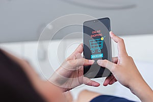 Woman using smartphone shopping online, shopping cart icon on screen mobile phone. purchase payment on internet