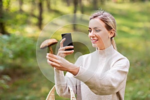 Woman using smartphone to identify mushroom