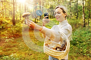 Woman using smartphone to identify mushroom