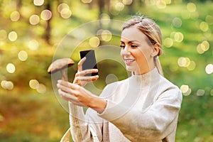 Woman using smartphone to identify mushroom