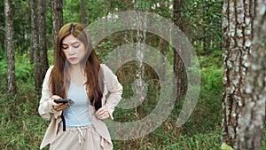 Woman using smartphone to navigation by eletronic map in the forrest