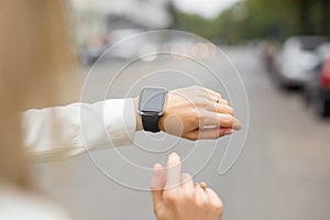 Woman using smartwatch on the street