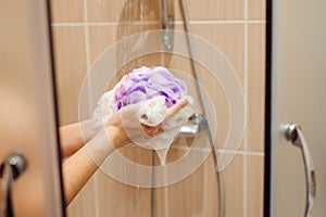 Woman using a soap while taking shower in a bathroom