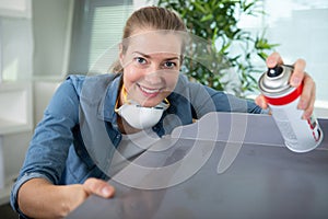 woman using spray paint on table