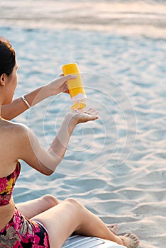 Woman using sun lotion on the beach