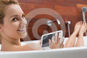 Woman using tablet in a bathtub