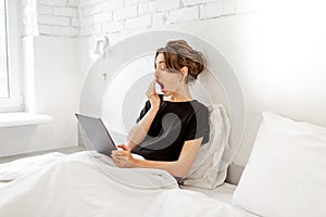 Woman using tablet in bed