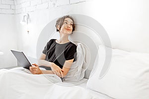 Woman using tablet in bed