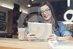 Woman using tablet in cafe