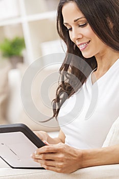 Woman Using Tablet Computer At Home on Sofa