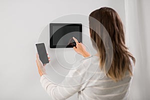 Woman using tablet computer and smartphone