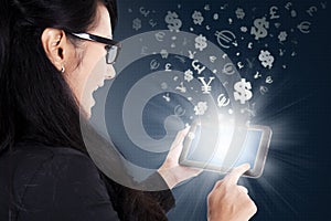 Woman using tablet with currency symbols