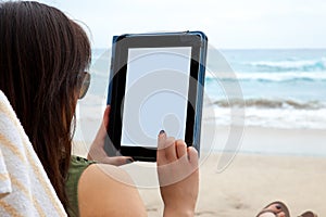 Woman using tablet device while on a beach