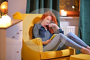 Woman  using a tablet on line at home sitting on a yellow in the living room at home . Covid isolation