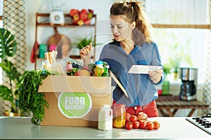 Woman using tablet PC app in kitchen