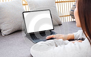 A woman using tablet pc with blank desktop white screen as a computer pc on sofa at home